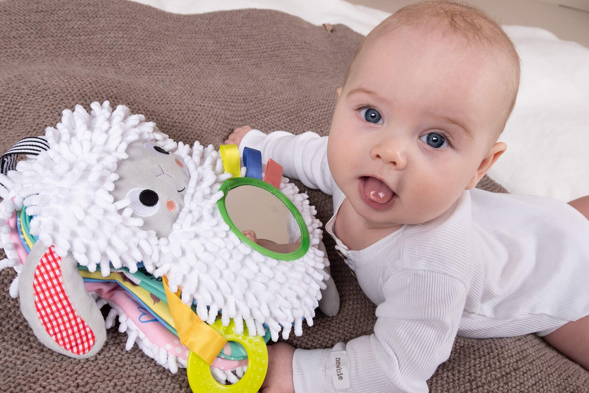 Baby som holder en myk bok